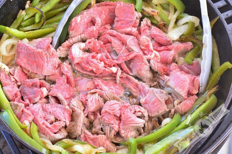 steak, onions, and peppers in the skillet