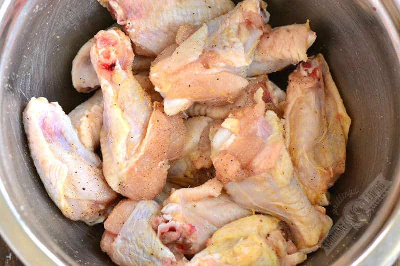 seasoned raw chicken wings in a mixing bowl
