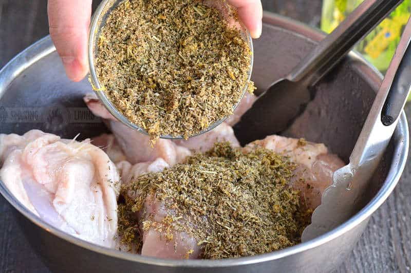 lemon herb chicken seasoning - pouring it over chicken