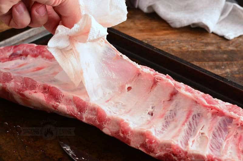 pulling the membrane off the bottom of the rack of baby back ribs