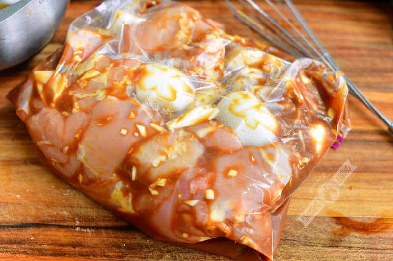chicken and onions with marinade in a gallon zip-lock bag