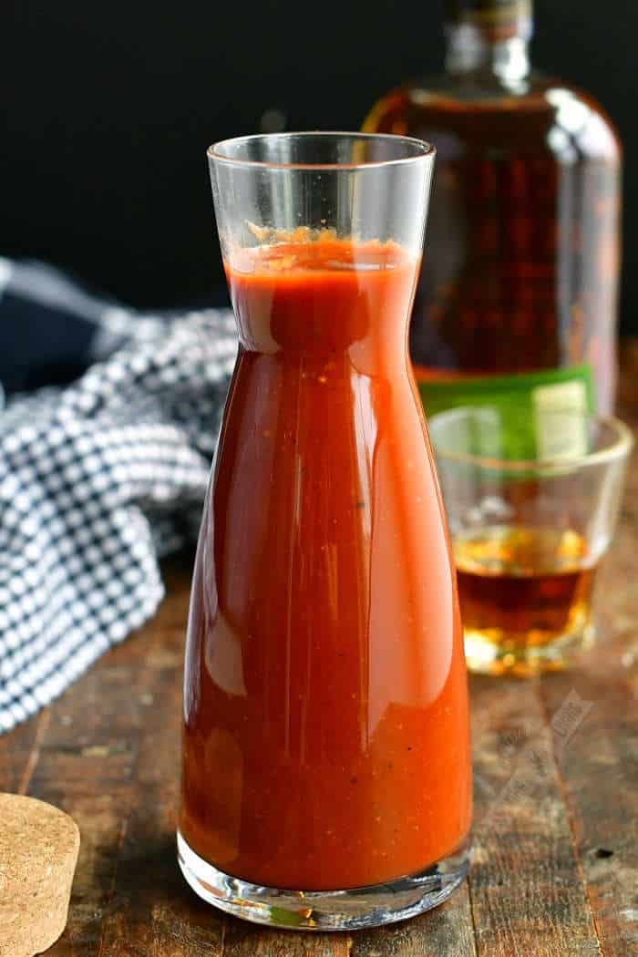 long glass jar filled with whiskey bbq sauce