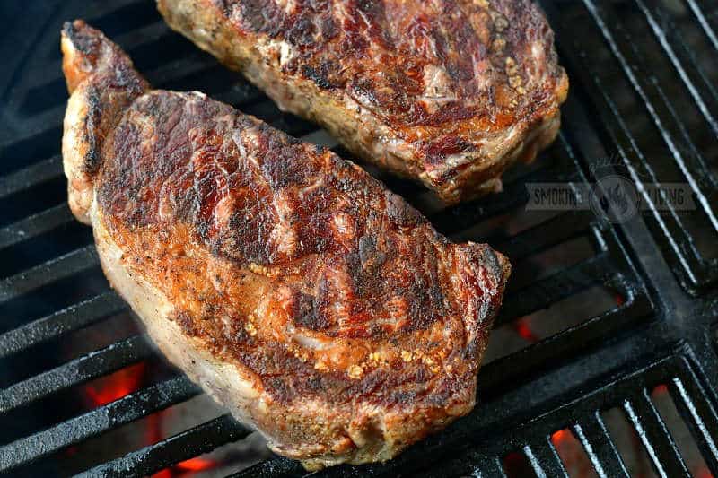 seared steak cooking on the grill grate
