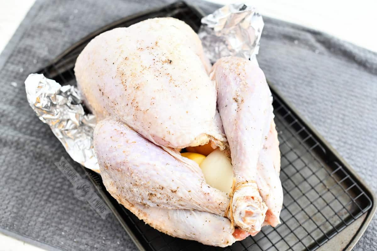 stuffed uncooked turkey on a wire rack ready to go on the smoker