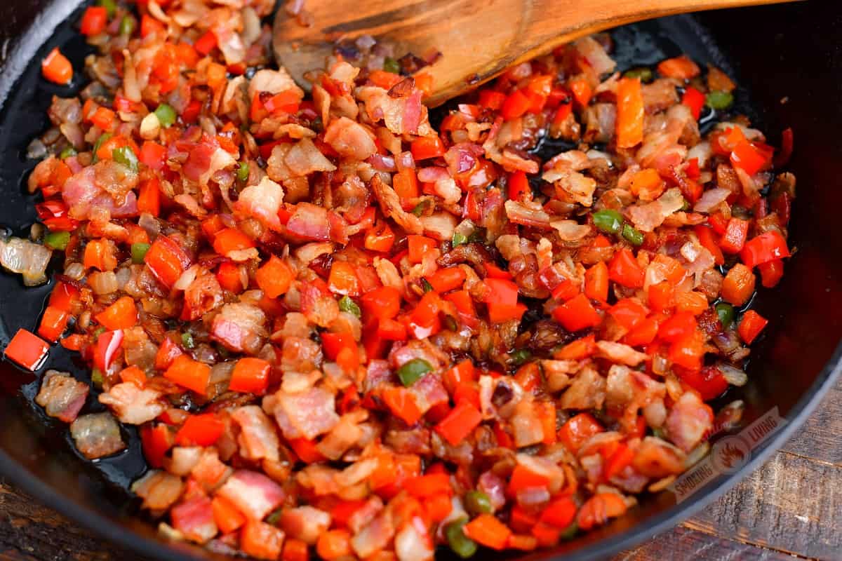 sautéed vegetables and bacon in a cast iron skillet