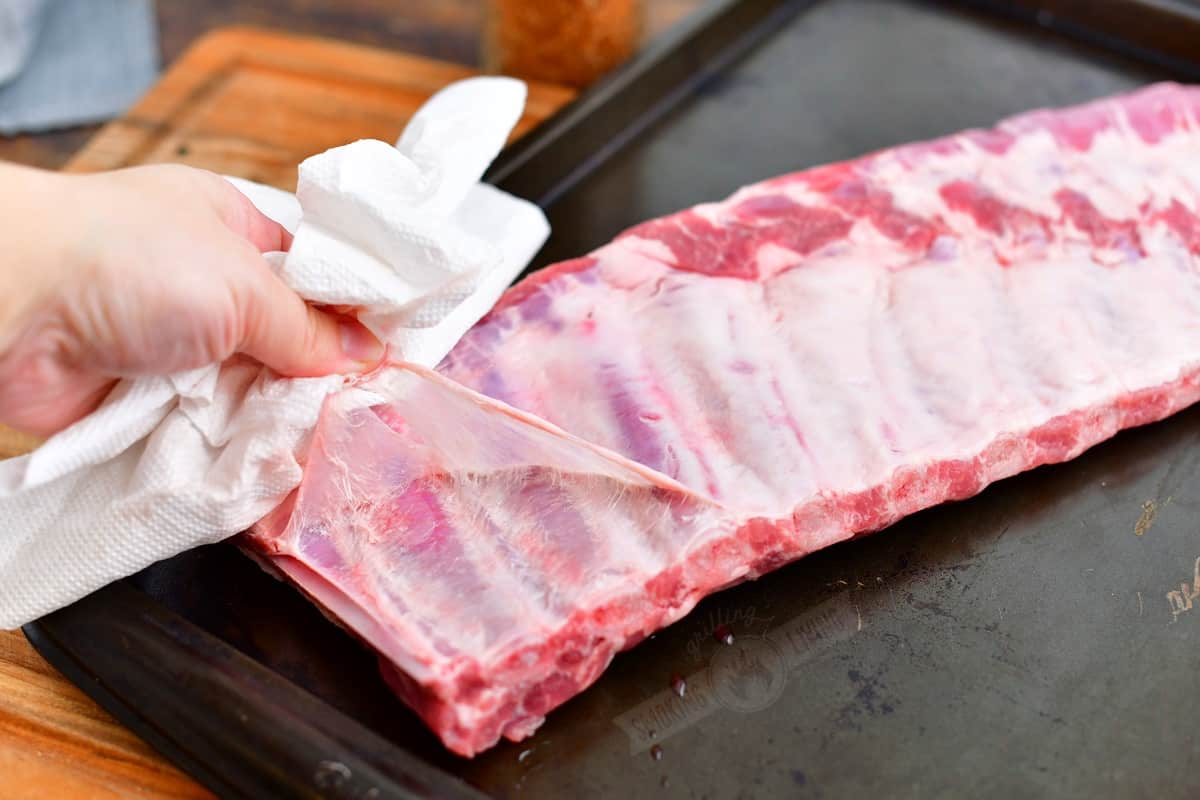 pulling off a membrane off the back of rack of ribs