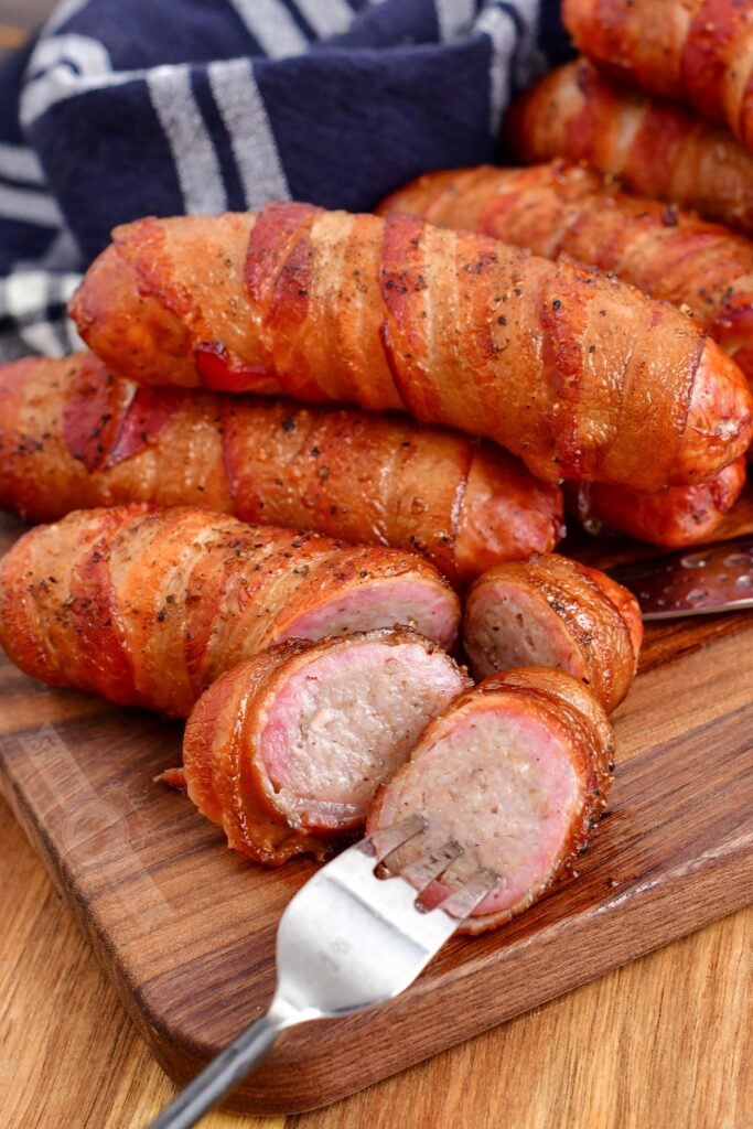 sliced smoked bacon wrapped sausage with a fork