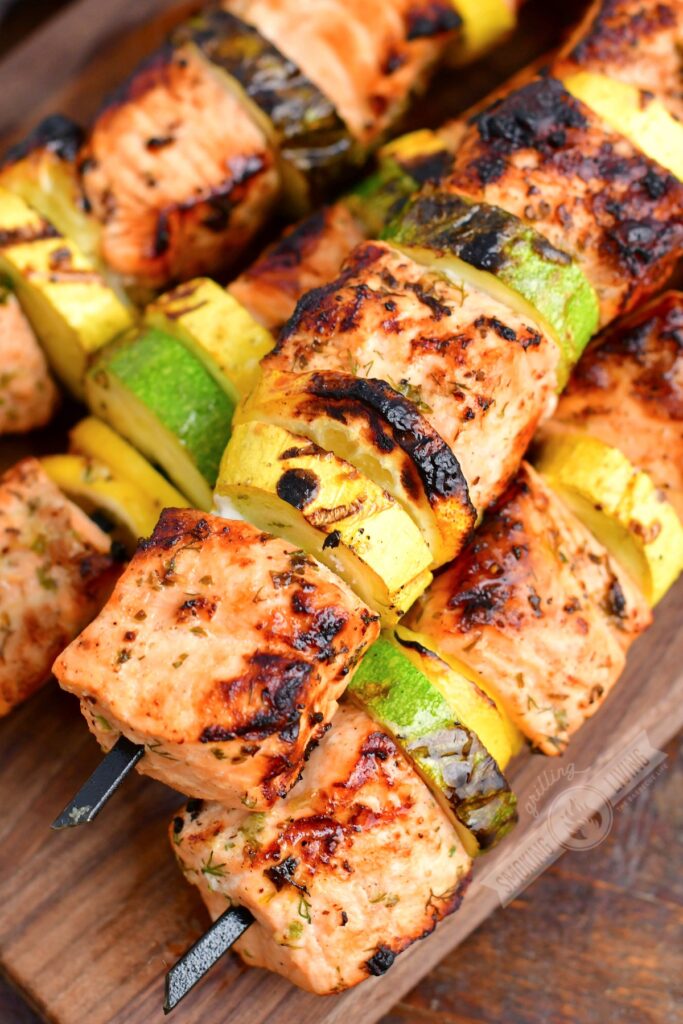 closeup of grilled salmon and vegetables on skewers