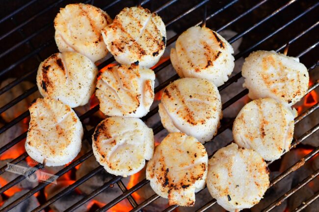 grilling scallops on skewers on the grill over charcoal