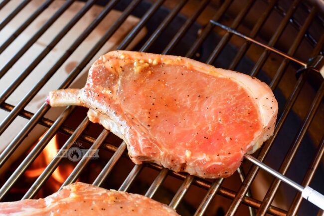 pork chop on the grill with thermometer inserted