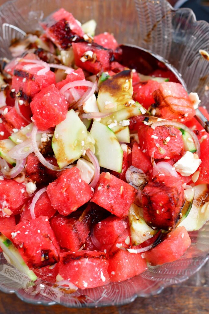 closeup of watermelon feta salad in a glass bowl with a spoon