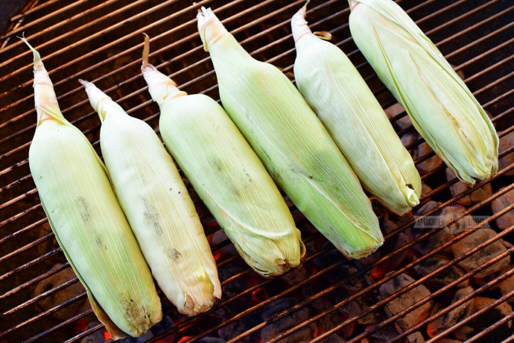 corn in husks placed on a grill