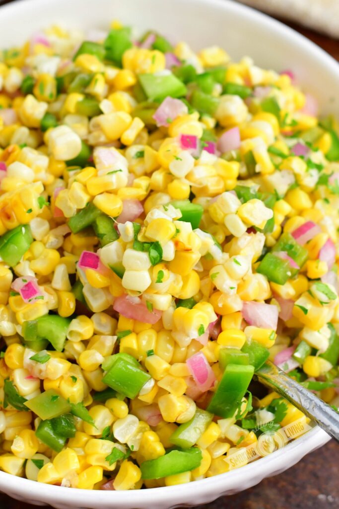 closeup scooping out some corn salad out of the bowl