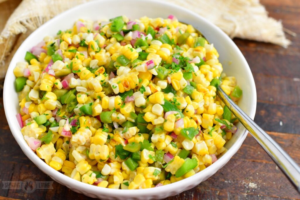 grilled corn salad in a whole serving bowl with a spoon