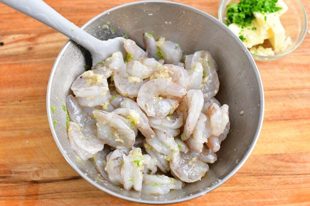 tossing shrimp with garlic and lime mixture in a bowl
