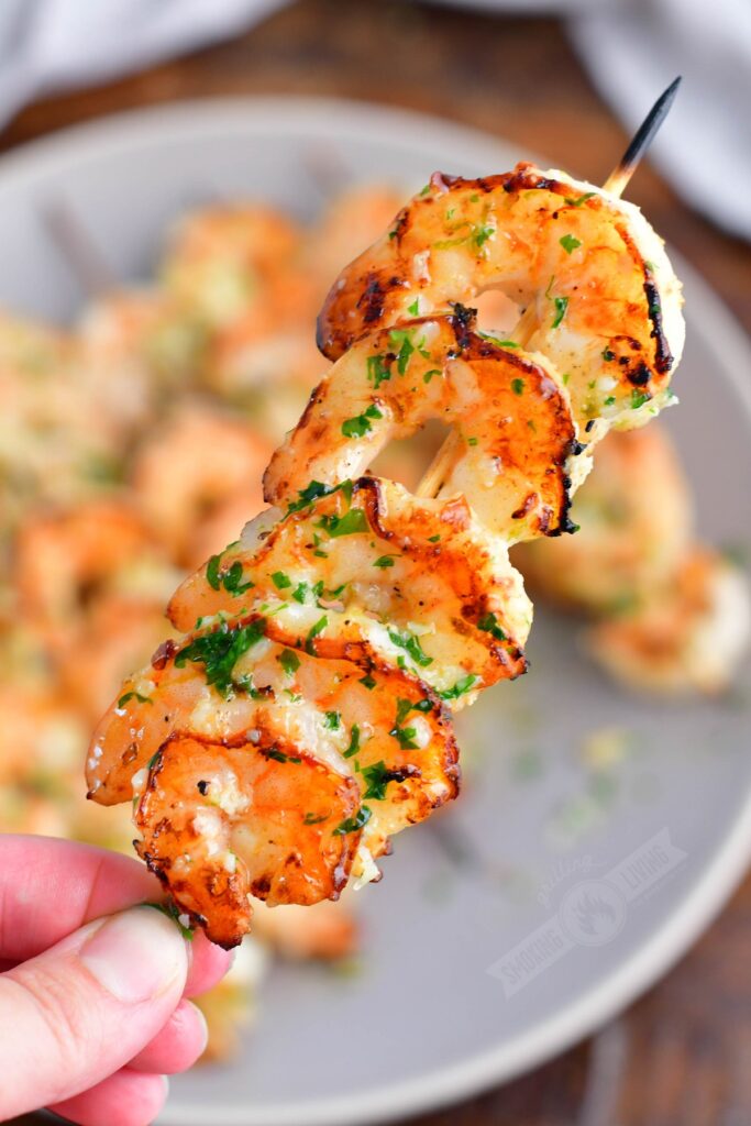 holding a shrimp skewer up close