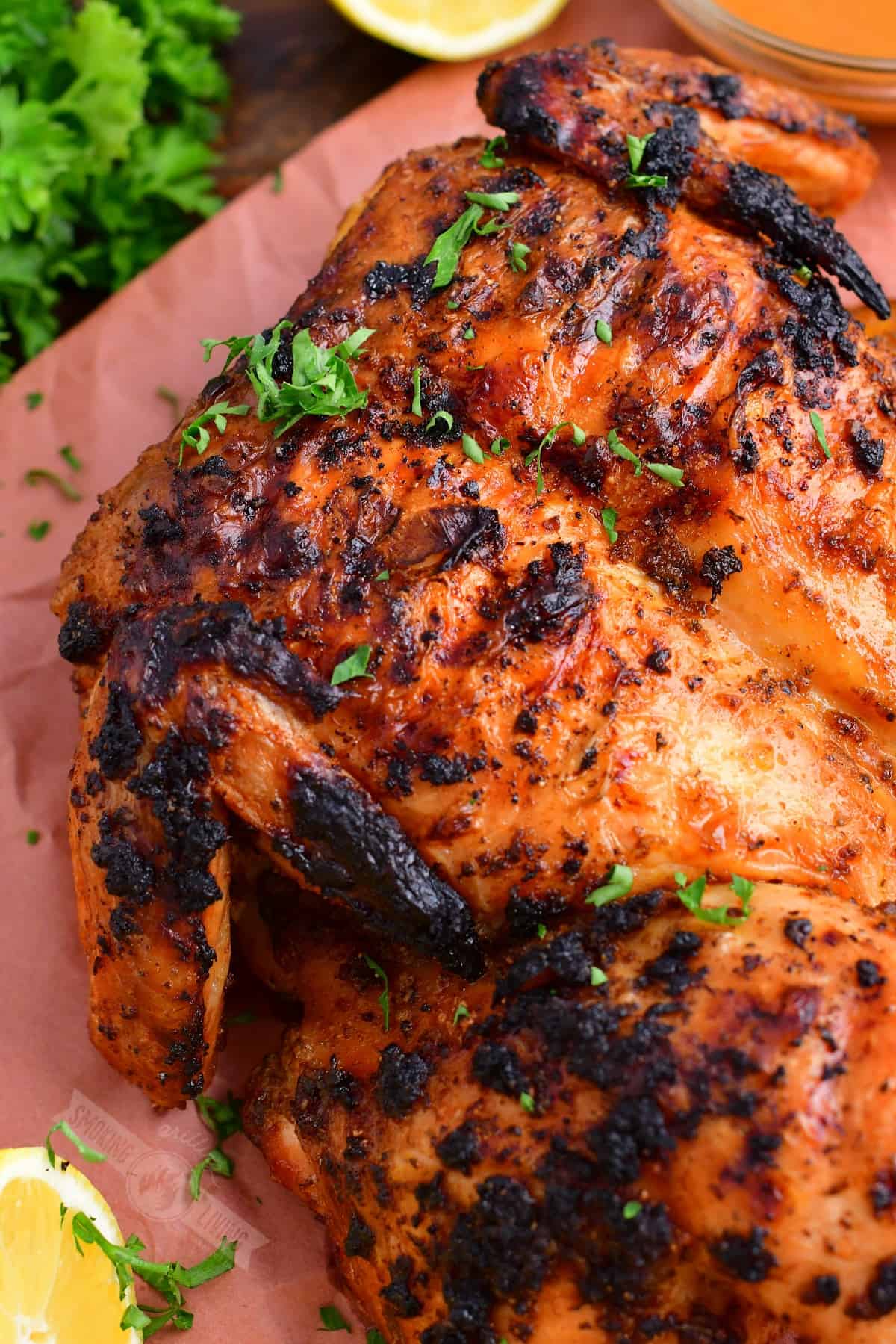 closeup of grilled whole chicken with parsley