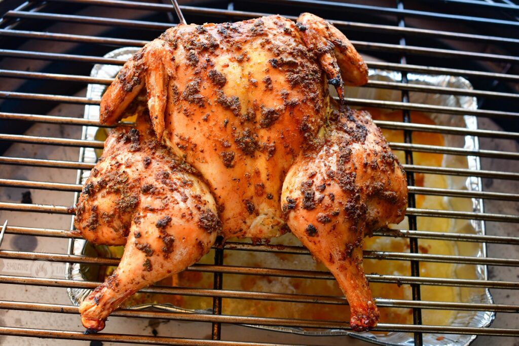 spatchcock chicken on the grill with drip pan underneath