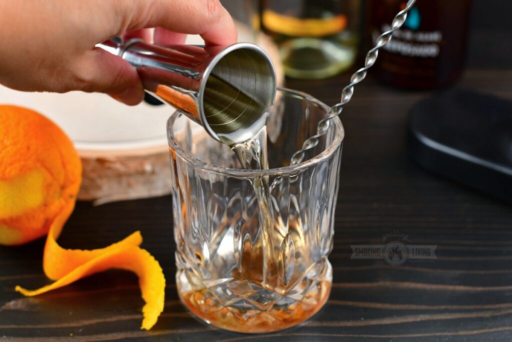 pouring tequila into an old fashioned glass