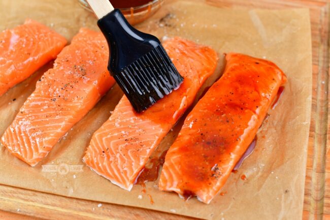 glazing salmon filet with BBQ mixture with a silicone brush