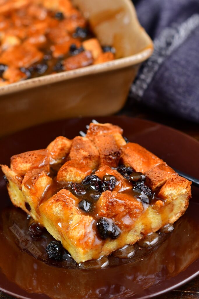 slice of smoked bread pudding on a brown plate with sauce