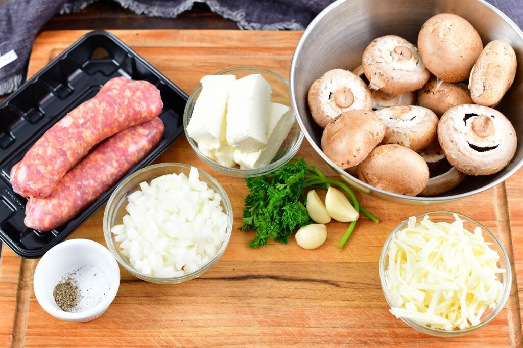 ingredients for sausage stuffed mushrooms on the cutting board
