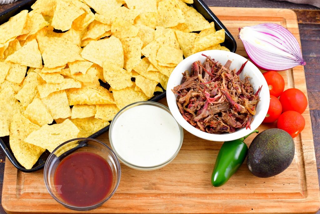 ingredients for beef nachos on a wooden board
