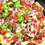 top view of loaded beef nachos on a baking sheet
