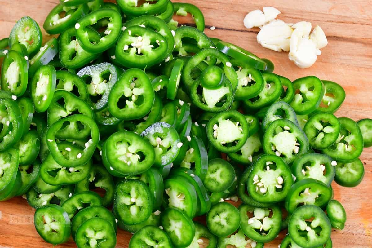 spiced jalapenos on a cutting board with garlic