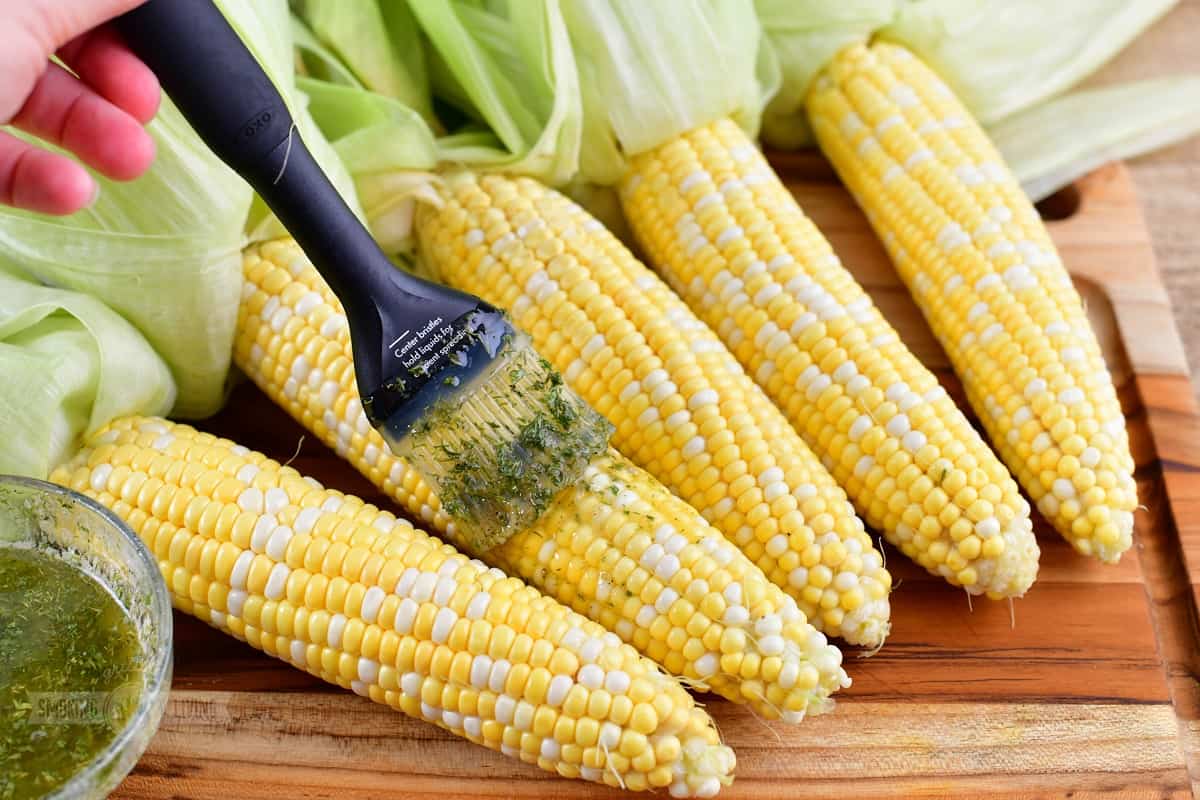 brushing the corn with melted butter mixed with seasoning