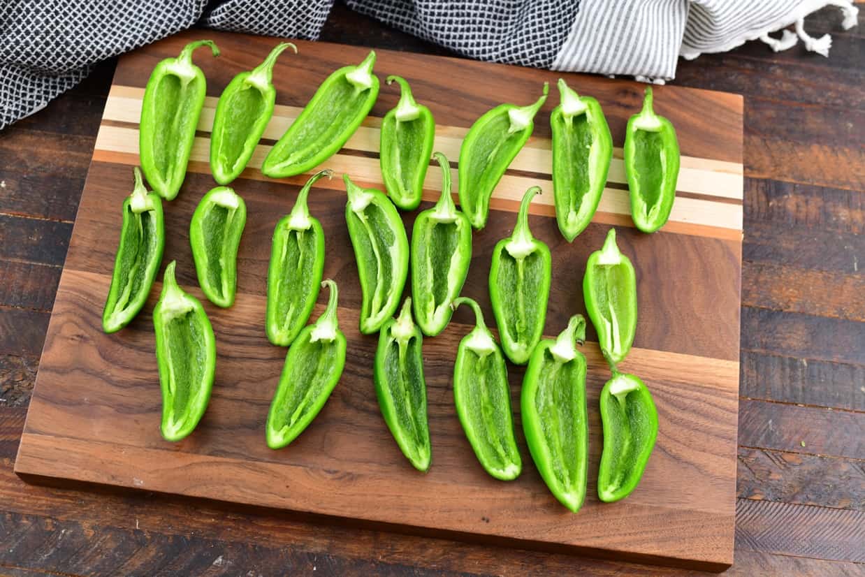 Raw peppers cut in half on wood