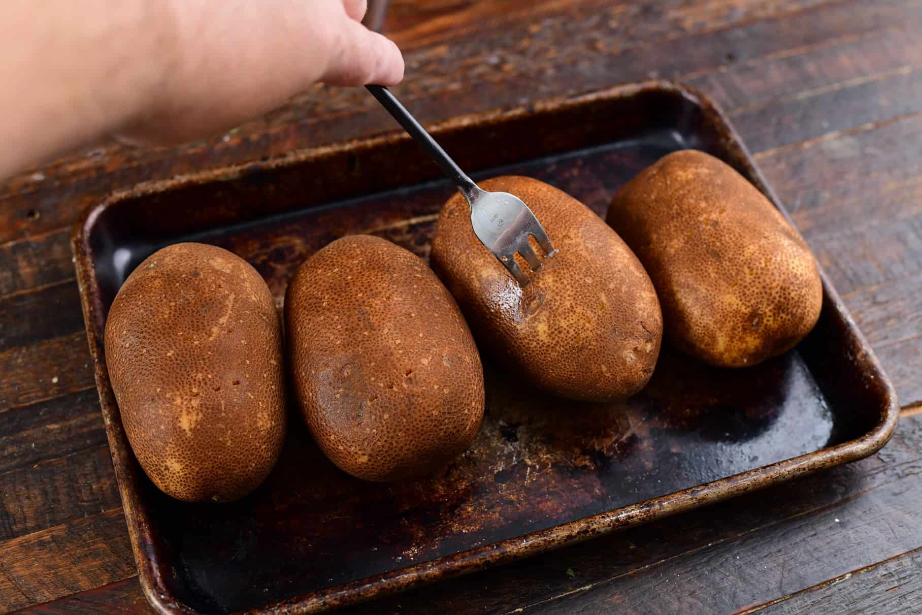 fork poking holes into potato