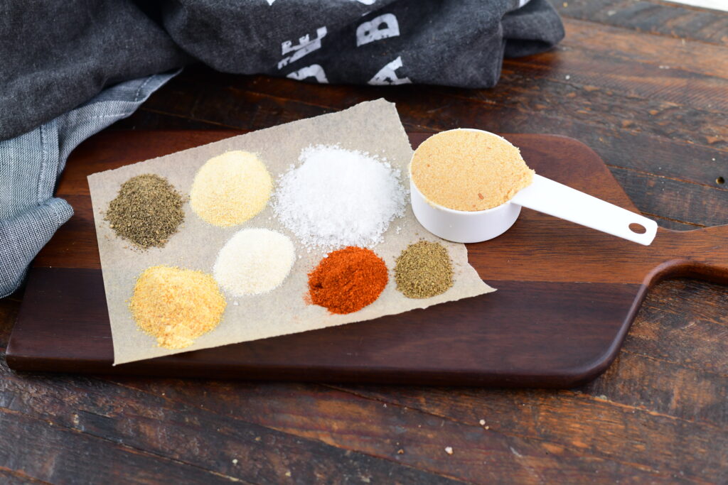 Ingredients for pork rub on a wooden decorative paddle.