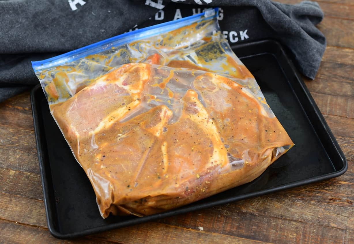 raw pork chops on a cooking tray finished marinating in a bag