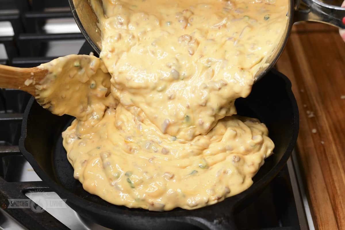 cooked queso dip being poured before smoking