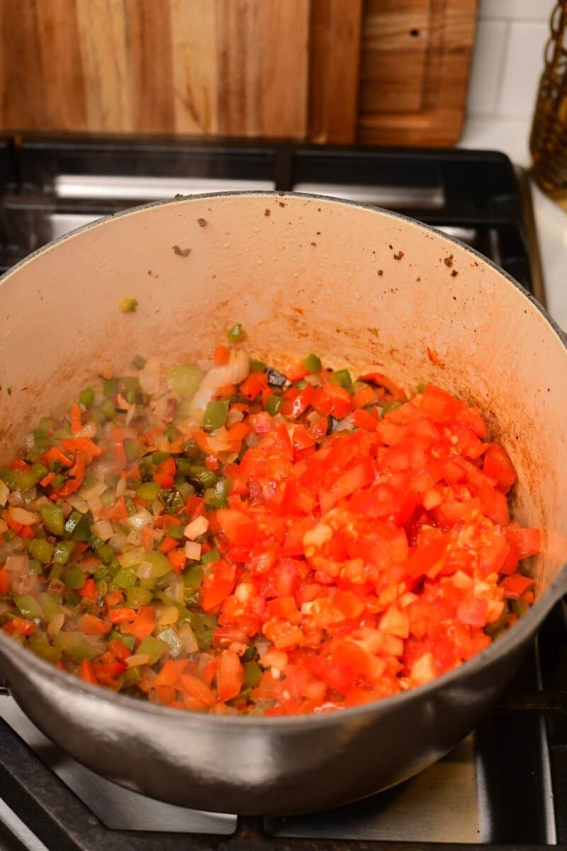 Diced tomatoes added to veggies.
