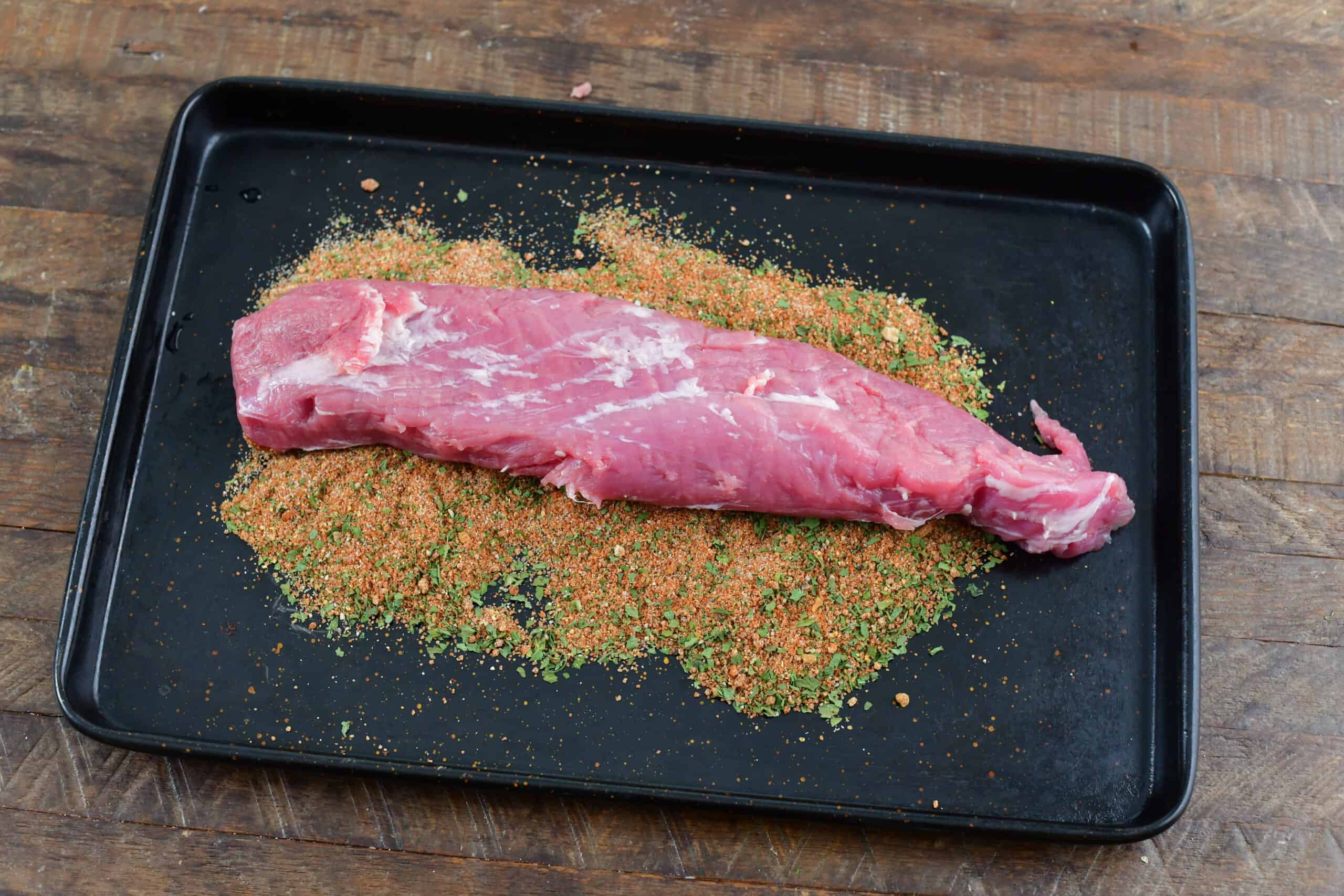 raw pork tenderloin on sheet tray before covering in dry rub