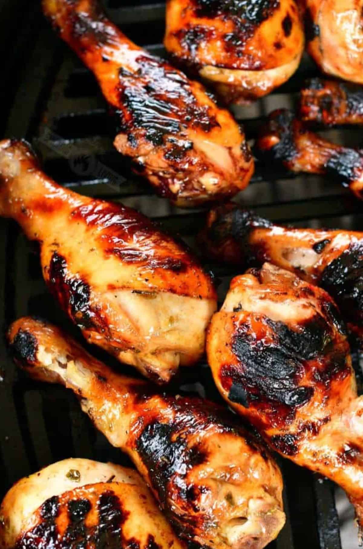Marinated grilled chicken legs on the grill.